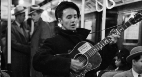 Woody Guthrie. The sign on his guitar says, "This machine kills fascists." He was a tenant at Beach Haven, the Trump's first major housing project, in 1950.